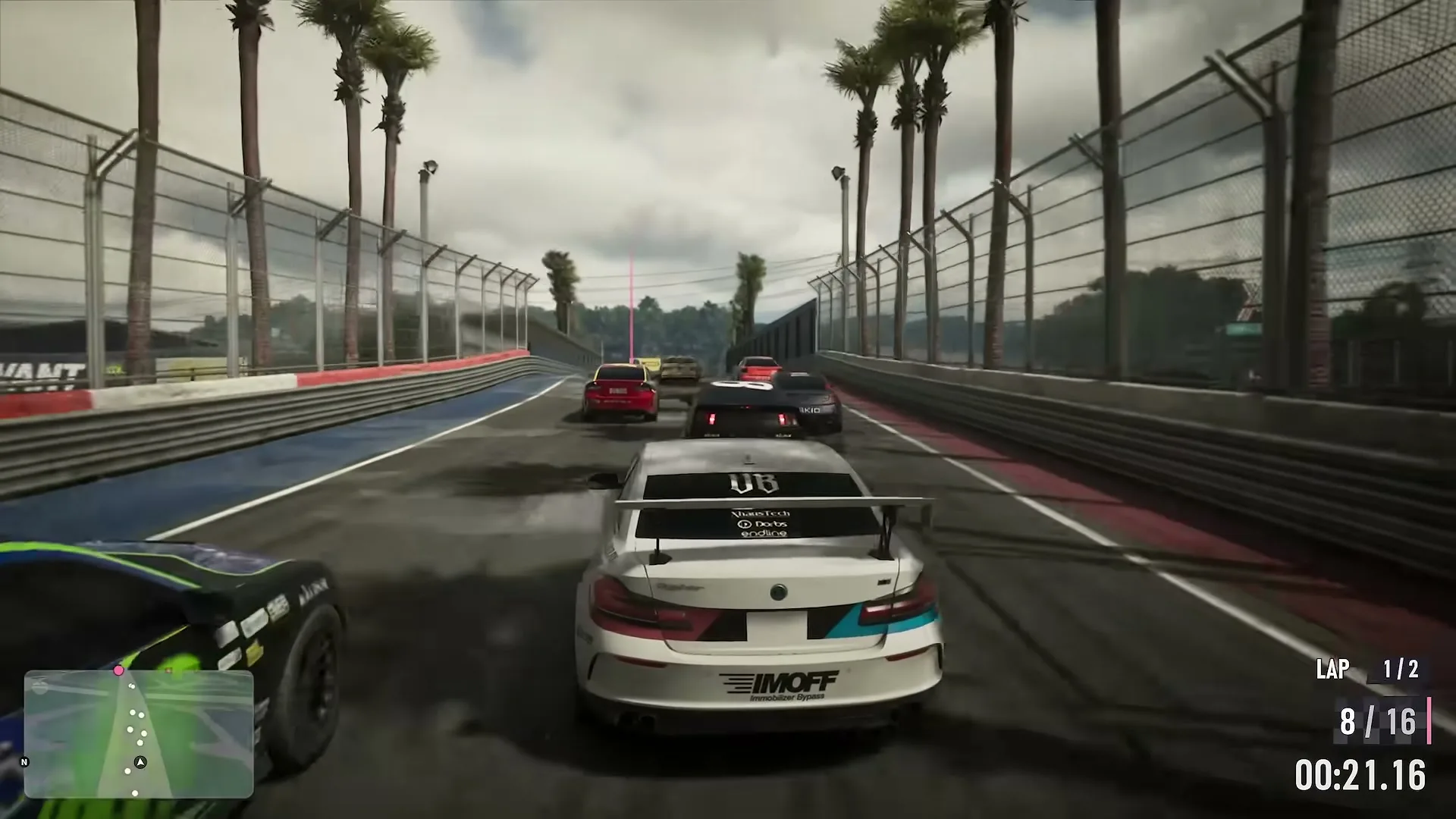 A pack of race cars on a palm-lined circuit, the player 8th of 16 on lap 1.