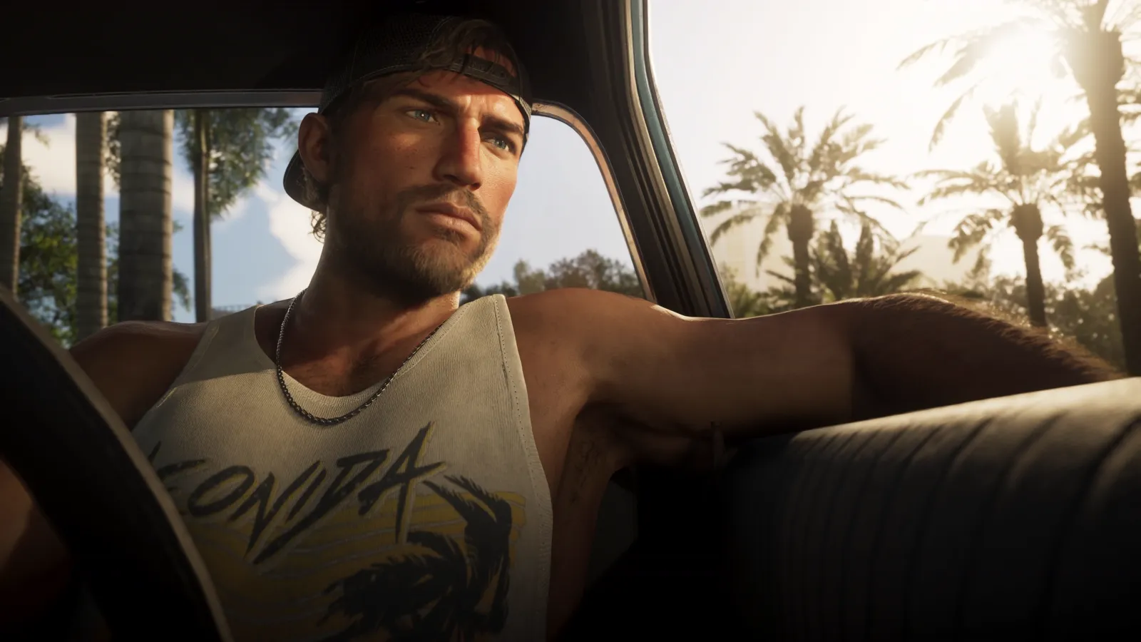Jason behind the wheel of a car, palm trees outside.