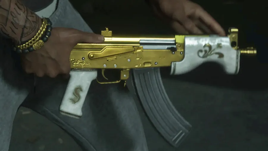 Close-up of a gold and pearl-white compact rifle with a dollar-sign grip panel held by a tattooed man, from an official GTA 6 Extended Look