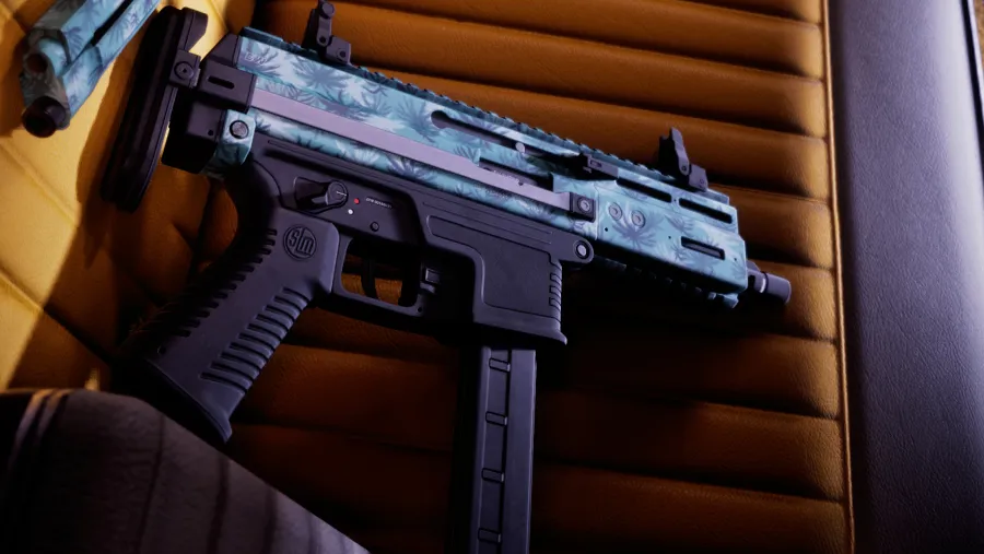 Close-up of a compact submachine gun finished in a blue palm-leaf pattern resting on a car seat, from an official GTA 6 screenshot