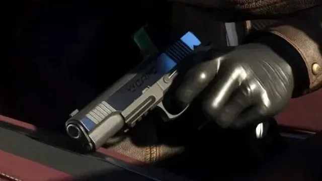 Close-up of a gloved hand holding a silver semi-automatic pistol in dim light, from an official GTA 6 screenshot