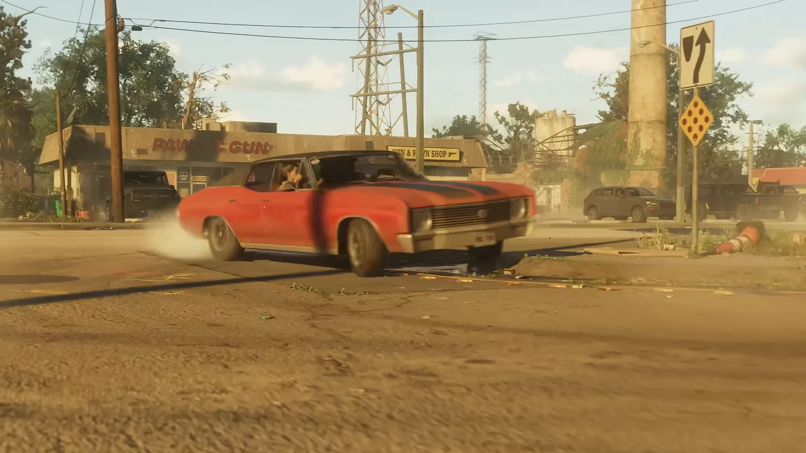 A red muscle car drifting away from a roadside store, from Trailer 1.